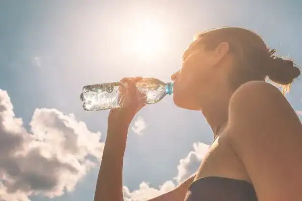 Image of woman drinking water to hydrate Eastleigh  after run.